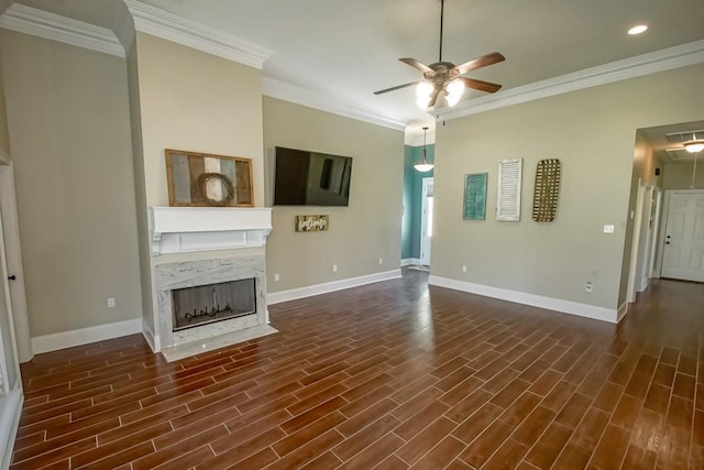 unfurnished living room with ceiling fan, a fireplace, crown molding, and dark wood-type flooring