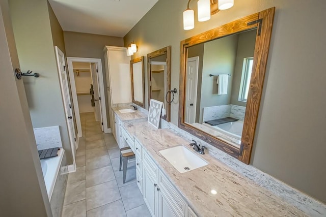 full bath with double vanity, a spacious closet, a sink, tile patterned flooring, and a bath