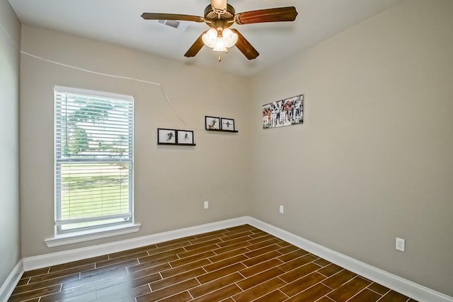 unfurnished room featuring ceiling fan, visible vents, baseboards, and dark wood finished floors