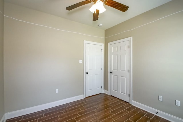 unfurnished room featuring wood tiled floor, baseboards, and ceiling fan