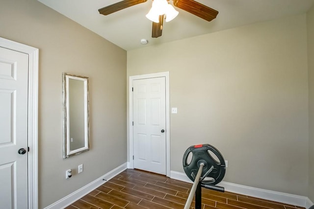 workout room featuring baseboards, ceiling fan, and wood tiled floor