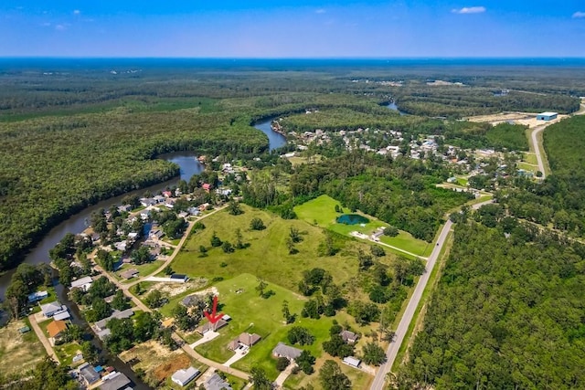 birds eye view of property featuring a water view and a wooded view