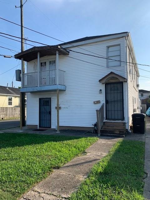 view of front property with a balcony and a front yard