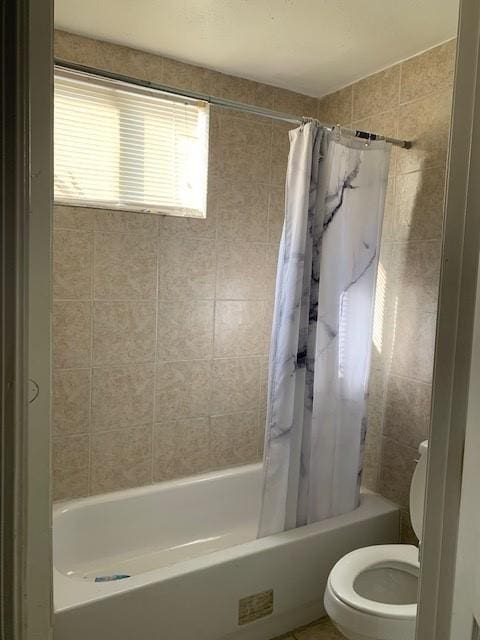 bathroom featuring tile patterned flooring, shower / tub combo, and toilet