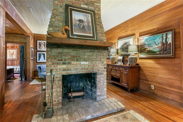 interior space with wood walls, wood-type flooring, and a fireplace