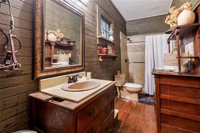 bathroom with toilet, wood walls, a shower with curtain, and vanity