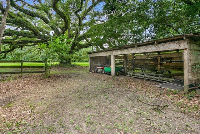 view of yard with an outdoor structure and fence