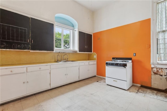 kitchen featuring white cabinetry, white gas range, and sink