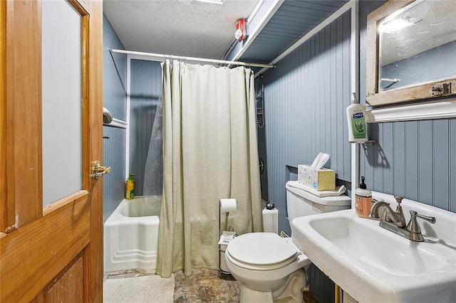 full bathroom featuring toilet, sink, wood walls, shower / tub combo, and a textured ceiling