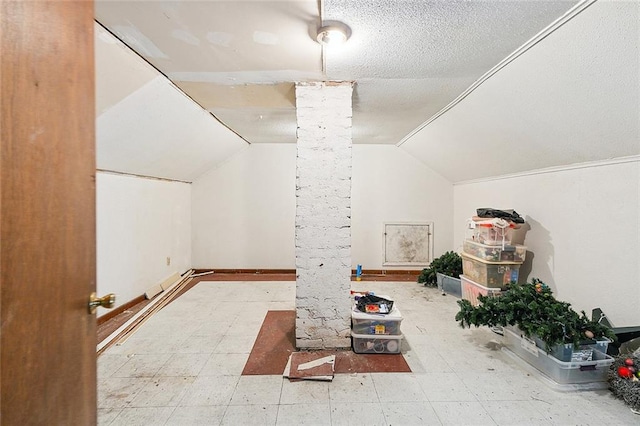 additional living space with lofted ceiling and a textured ceiling