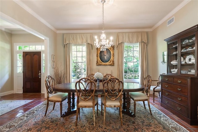 dining area featuring an inviting chandelier, dark tile patterned flooring, a wealth of natural light, and crown molding