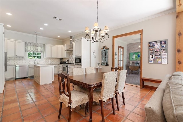 tiled dining area featuring ornamental molding, sink, and a chandelier