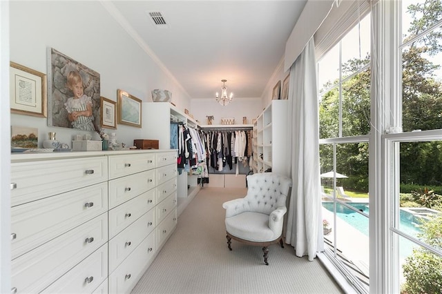 spacious closet with a chandelier and light colored carpet