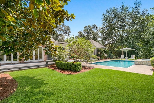 view of swimming pool with an in ground hot tub and a yard