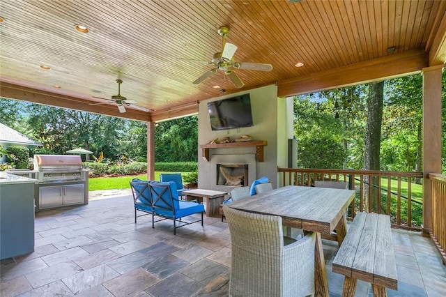 view of patio featuring grilling area, ceiling fan, and exterior fireplace