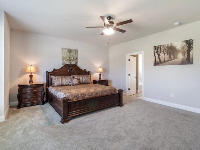 bedroom with light carpet, baseboards, and a ceiling fan