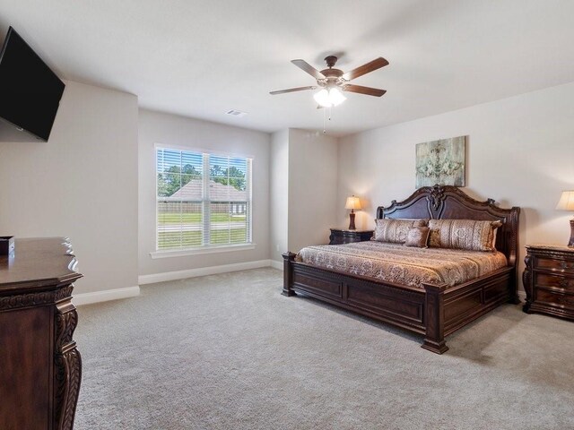 bedroom featuring baseboards, ceiling fan, and light colored carpet