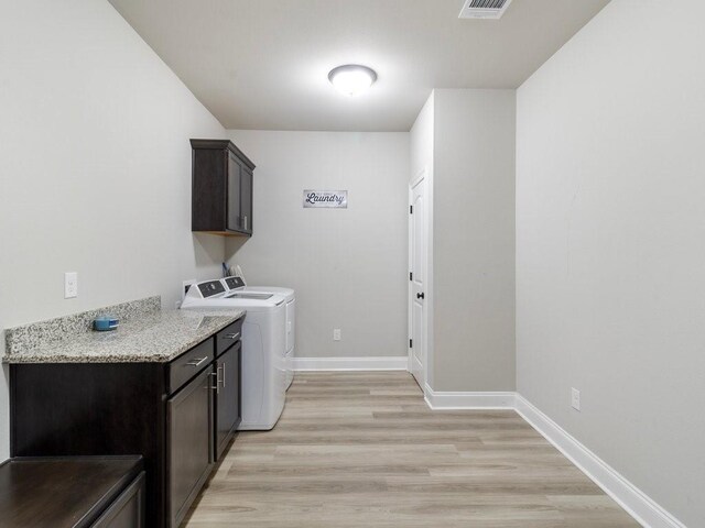 laundry room with cabinet space, visible vents, baseboards, light wood-type flooring, and separate washer and dryer