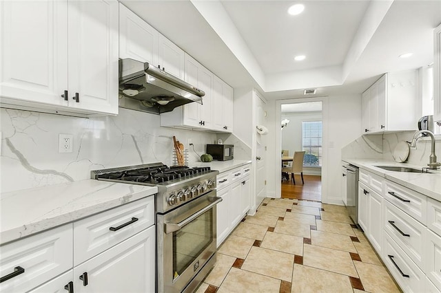 kitchen with decorative backsplash, white cabinetry, sink, and appliances with stainless steel finishes