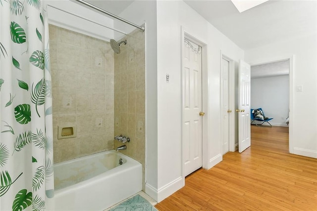 bathroom with hardwood / wood-style floors and shower / bathtub combination with curtain