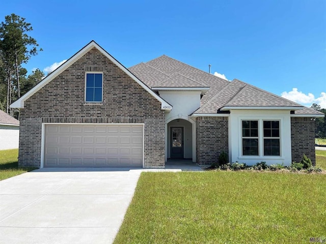 view of front of home with roof with shingles, a front lawn, concrete driveway, and brick siding