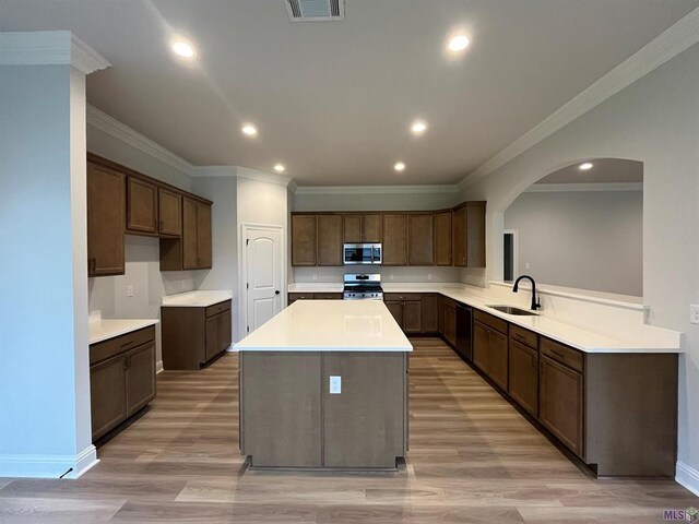 kitchen with recessed lighting, a sink, stainless steel appliances, a center island, and crown molding