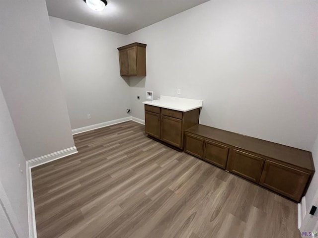 clothes washing area with hookup for a washing machine, hookup for an electric dryer, dark wood-type flooring, and cabinets