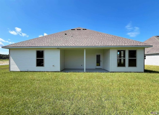 rear view of house featuring a lawn and a patio area