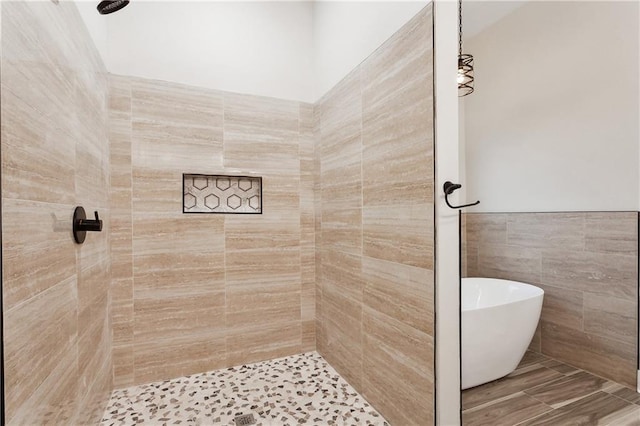 bathroom with separate shower and tub and tile walls