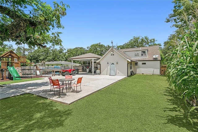 rear view of property featuring a yard, a playground, and a patio