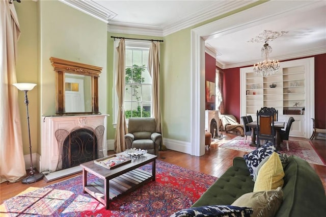 sitting room with wood-type flooring, ornamental molding, and a chandelier