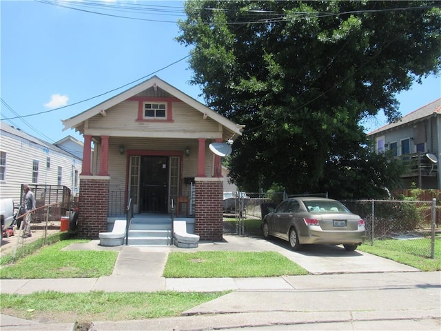 8719 Fig St, New Orleans, LA 70118 - view of front of home with a gate, a porch, fence, and brick siding