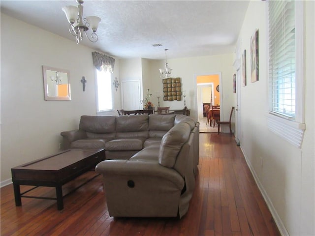 8719 Fig St, New Orleans, LA 70118 - living room featuring baseboards, a notable chandelier, hardwood / wood-style flooring, and a textured ceiling