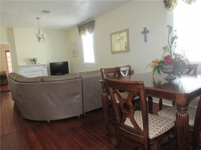 8719 Fig St, New Orleans, LA 70118 - living room featuring dark wood-style flooring, a chandelier, and visible vents