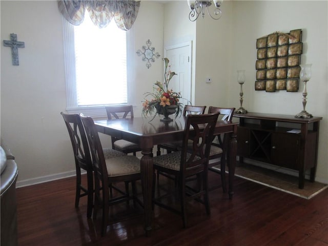 dining space featuring dark hardwood / wood-style flooring and a chandelier