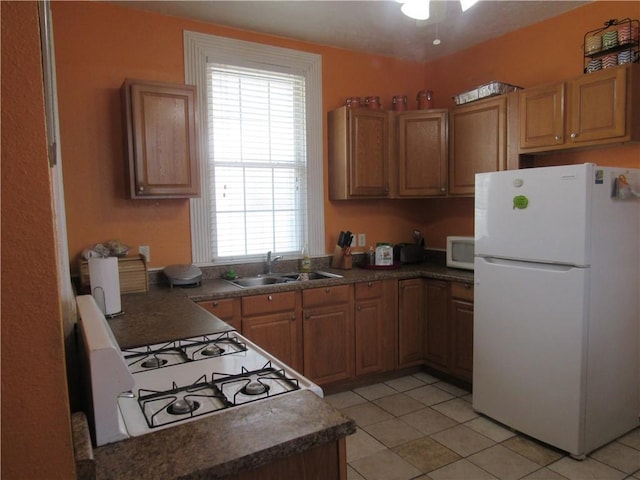 8719 Fig St, New Orleans, LA 70118 - kitchen featuring a sink, dark countertops, light tile patterned floors, and white appliances