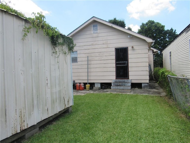 8719 Fig St, New Orleans, LA 70118 - rear view of house with fence, a yard, and entry steps