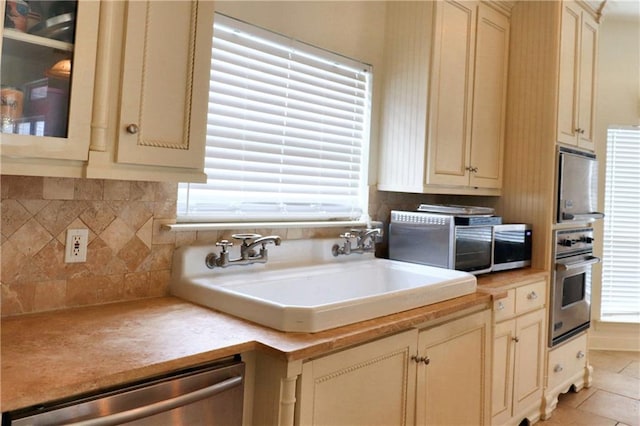 kitchen with decorative backsplash, stainless steel appliances, sink, and plenty of natural light