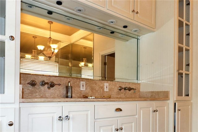 bathroom featuring a chandelier, backsplash, and vanity