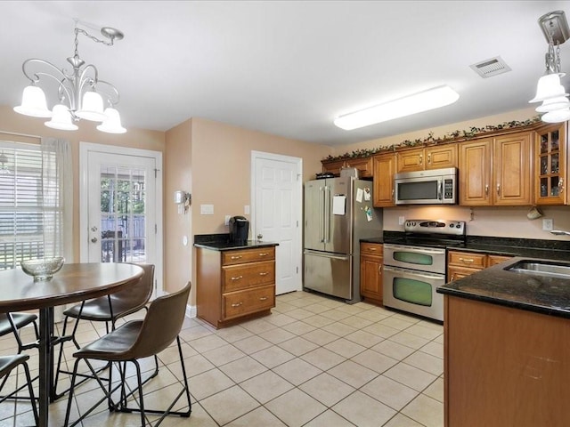 kitchen with sink, hanging light fixtures, a notable chandelier, and appliances with stainless steel finishes