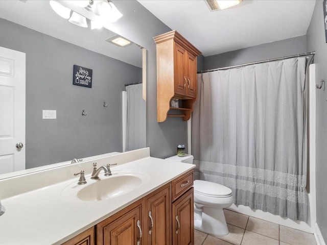 full bathroom featuring tile patterned flooring, vanity, toilet, and shower / bath combo with shower curtain