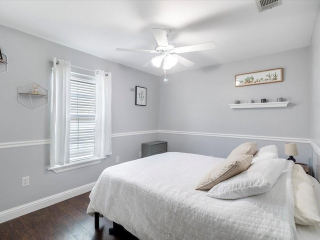 bedroom featuring multiple windows, dark hardwood / wood-style flooring, and ceiling fan