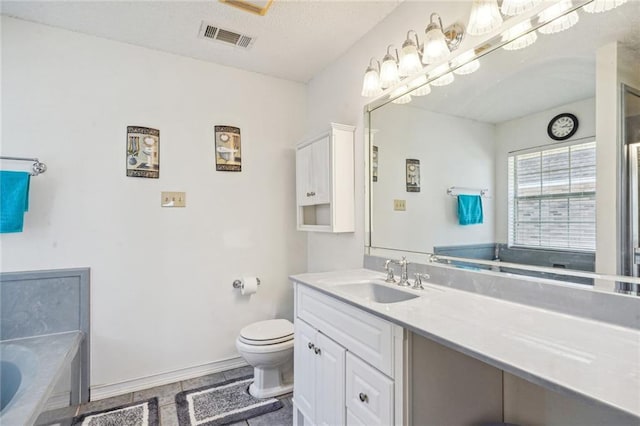 bathroom with vanity, tile patterned floors, a bathing tub, toilet, and a textured ceiling