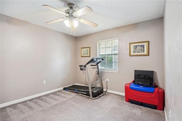 exercise area featuring a textured ceiling, carpet floors, and ceiling fan