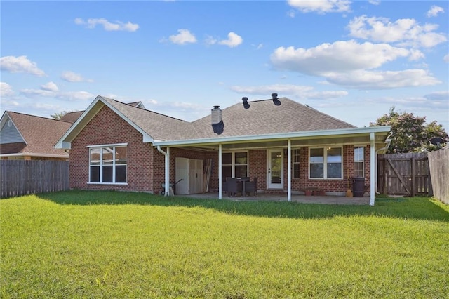 back of house featuring a patio area and a lawn