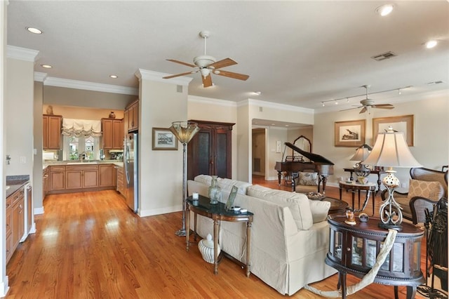 living room with light hardwood / wood-style floors, crown molding, and ceiling fan