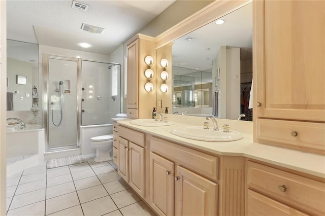 bathroom with toilet, a shower with shower door, vanity, and tile patterned flooring