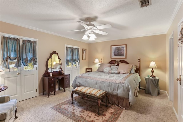 bedroom featuring light carpet, crown molding, a textured ceiling, and ceiling fan