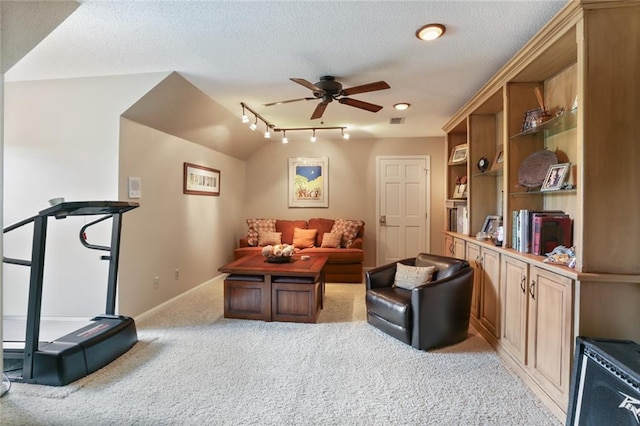 interior space with a textured ceiling, track lighting, and ceiling fan