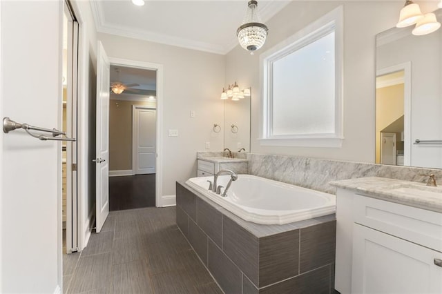 bathroom featuring tiled tub, vanity, and ornamental molding